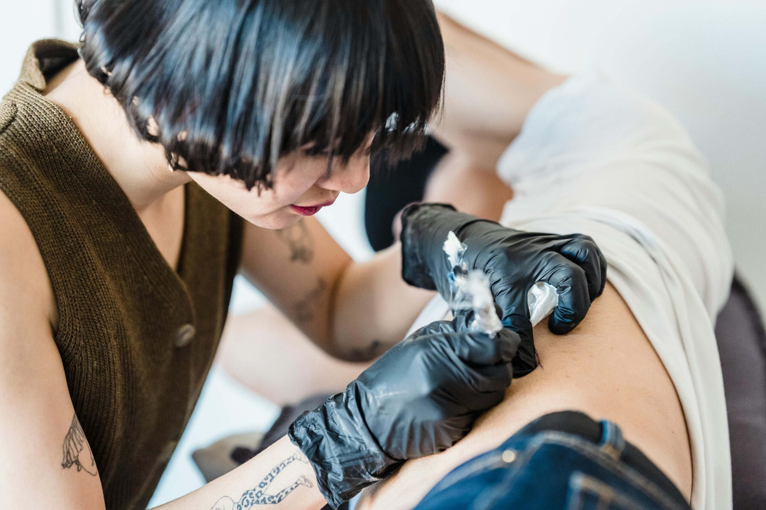 Tattoo artist working with a returning client in a studio
