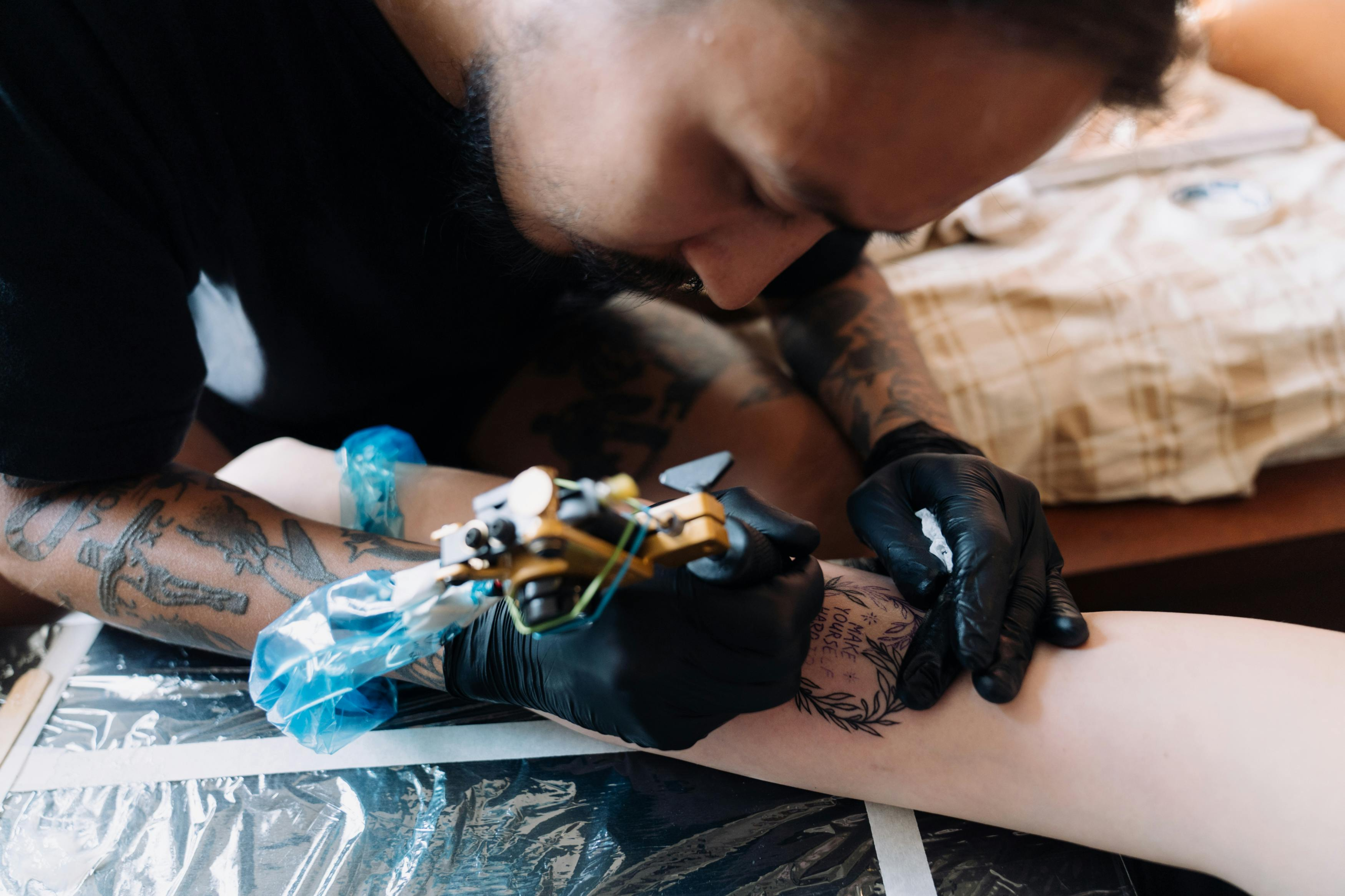 Tattoo artist checking a modern, professional website portfolio on a laptop